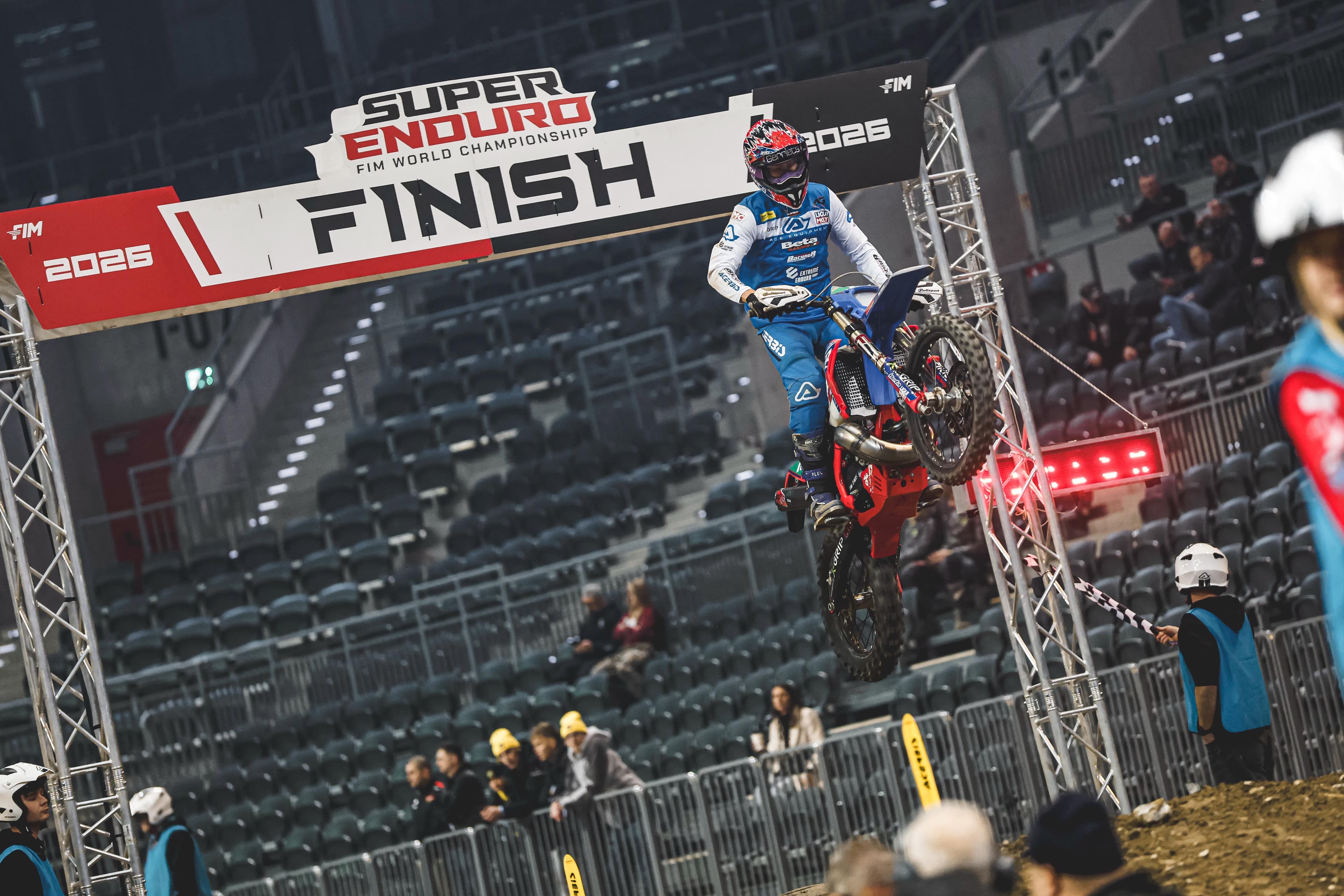 Ein Motocross-Fahrer springt auf seinem Motorrad durch den Zielbogen der SuperEnduro FIM Weltmeisterschaft.